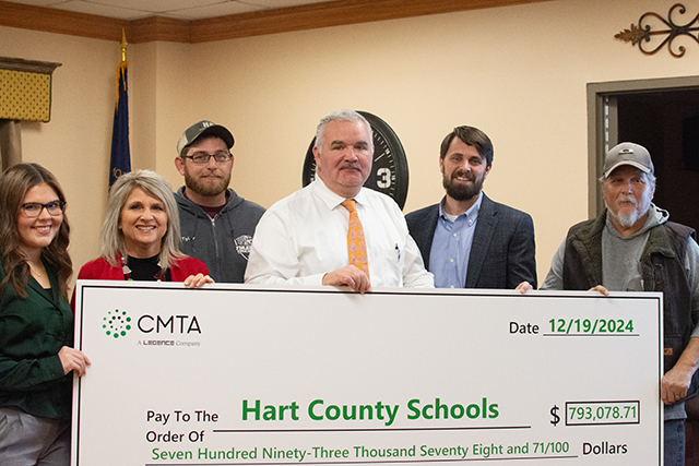 Hart County Schools Student Representative Emma Sanders, HCS School Board Vice Chairman Tina Rutledge, HCS School Board Member Tyler Holthouser, HCS Superintendent Nathan Smith, CMTA Project Manager Jason Pollan and HCS School Board Member Wesley Hodges pose for a picture with a $793,078.71 ceremonial check at the school board’s Thursday meeting, representing funds of the same amount earned through the installation of a geothermal well field.