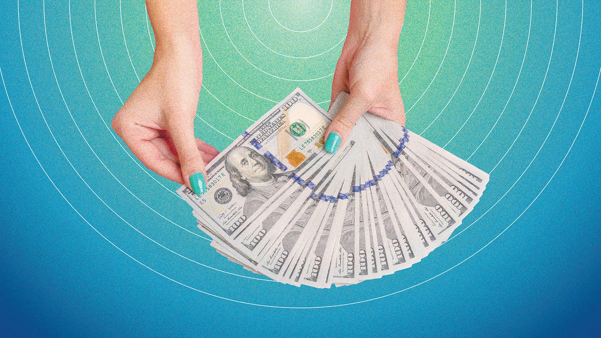 hands with teal nails holding a fan of cash against a teal background